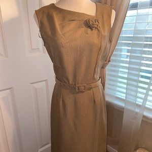 Tan business dress. Mid length. Sleeveless.